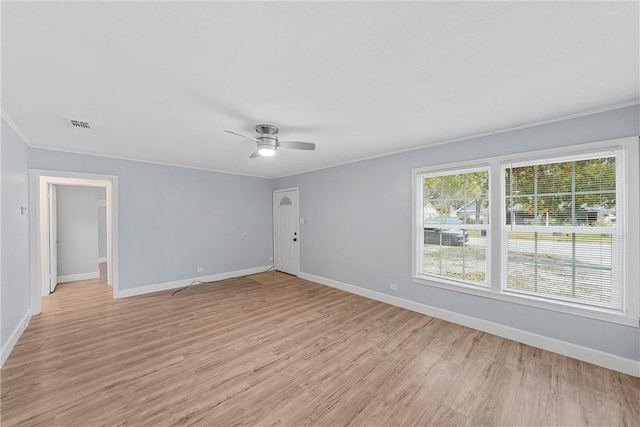 empty room featuring ceiling fan, light wood-type flooring, and crown molding