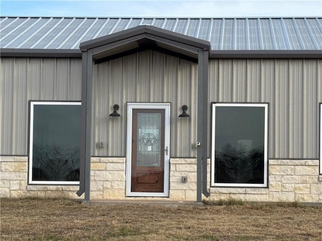 view of exterior entry with a lawn