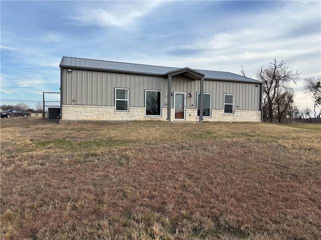 view of front of property featuring central AC unit and a front lawn