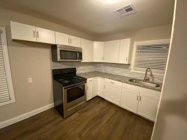 kitchen featuring backsplash, white cabinetry, sink, and appliances with stainless steel finishes