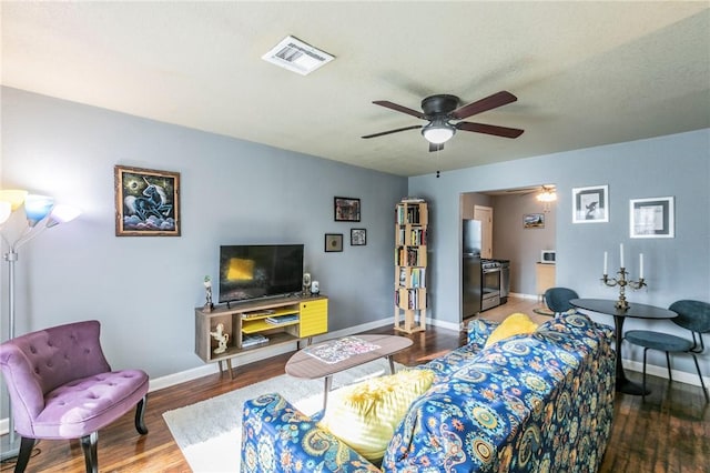 living room with wood-type flooring and ceiling fan