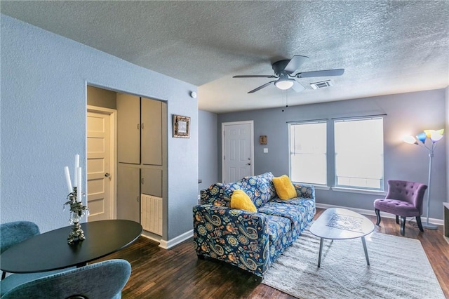 living room featuring a textured ceiling, dark wood-type flooring, and ceiling fan