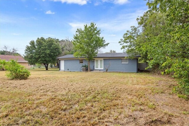 rear view of property with a yard