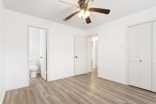 unfurnished bedroom featuring ceiling fan, a closet, connected bathroom, and light hardwood / wood-style flooring