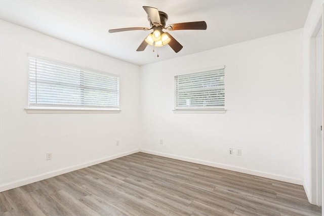 empty room with hardwood / wood-style floors and ceiling fan