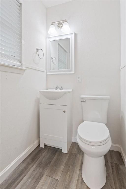 bathroom with vanity, hardwood / wood-style flooring, and toilet