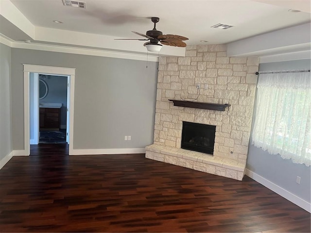 unfurnished living room featuring ceiling fan, a fireplace, and dark wood-type flooring