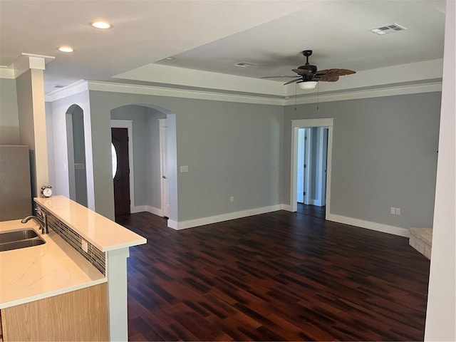 interior space featuring ceiling fan, sink, dark wood-type flooring, and ornamental molding