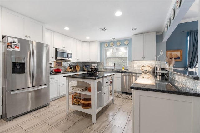 kitchen with visible vents, open shelves, a sink, stainless steel appliances, and white cabinets