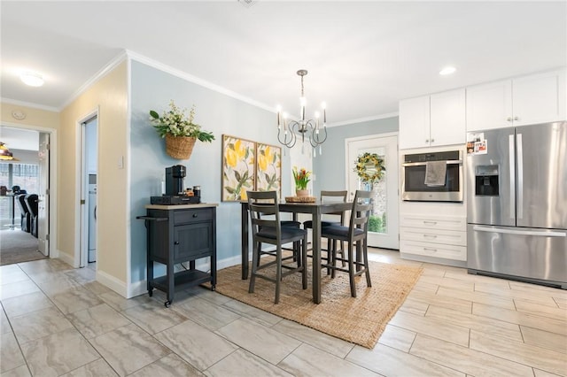 dining area with a chandelier, crown molding, and baseboards