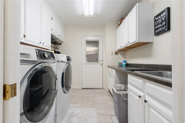 laundry area featuring cabinet space, washing machine and dryer, and a sink