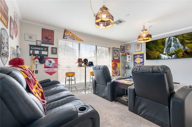 carpeted home theater room with visible vents and ornamental molding