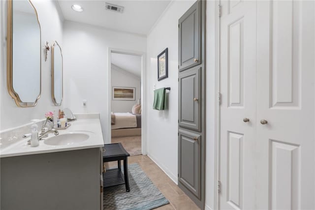 full bath with visible vents, double vanity, ornamental molding, a sink, and ensuite bathroom