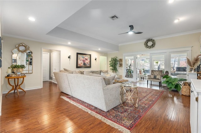 living area featuring crown molding, visible vents, and wood-type flooring