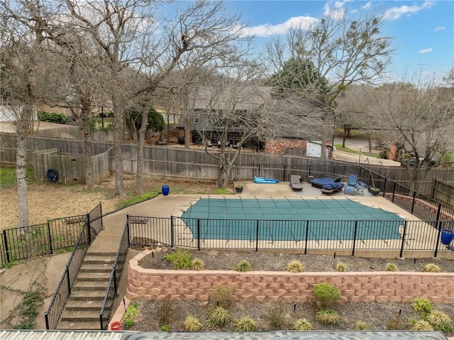 view of swimming pool with a patio area, a fenced in pool, and fence