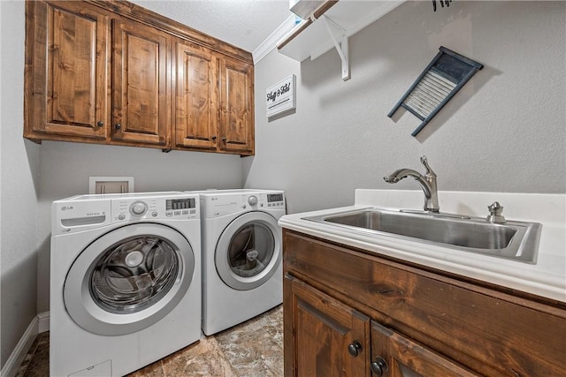 washroom with cabinets, sink, and washing machine and clothes dryer