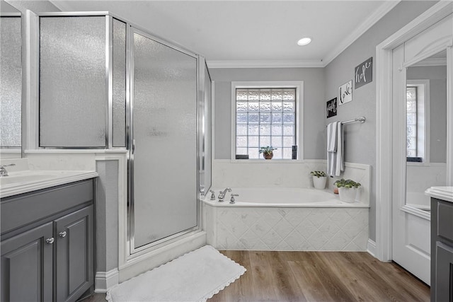 bathroom with vanity, shower with separate bathtub, ornamental molding, and wood-type flooring