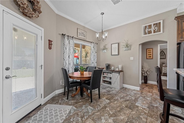 dining space with ornamental molding and a chandelier