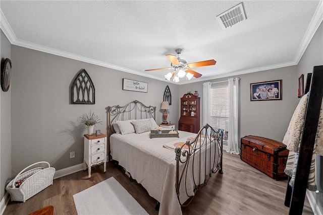 bedroom featuring ceiling fan, wood-type flooring, crown molding, and a textured ceiling