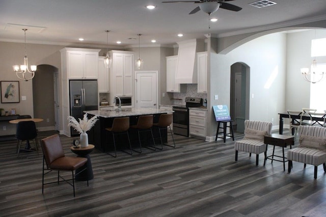 kitchen featuring a center island with sink, white cabinets, custom exhaust hood, and appliances with stainless steel finishes