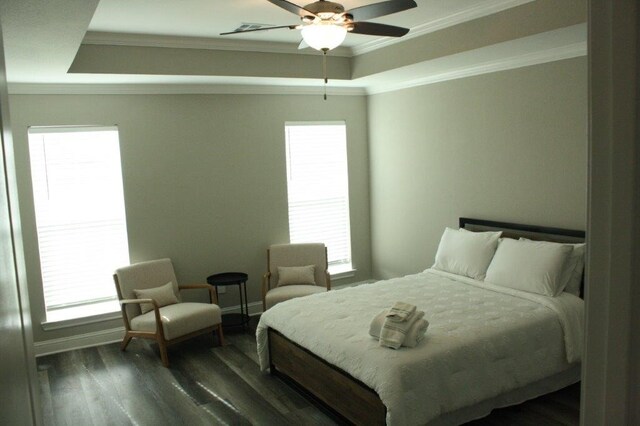 bedroom featuring dark hardwood / wood-style floors, ceiling fan, and multiple windows