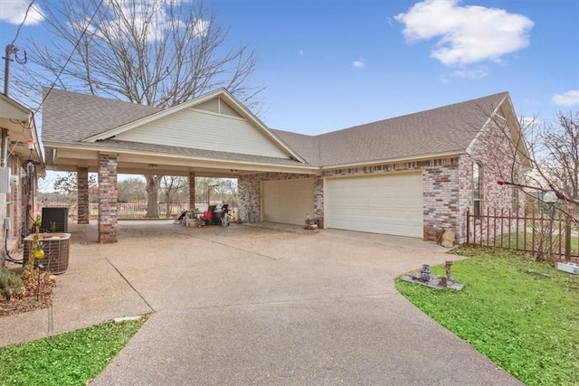 view of front of home with a garage, central AC, and a front lawn