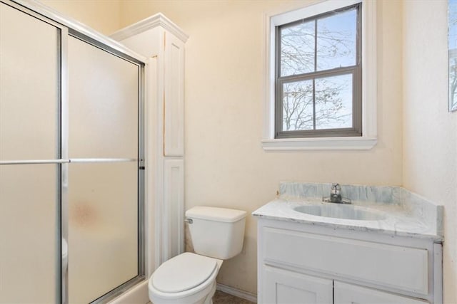 bathroom with vanity, toilet, and a shower with shower door