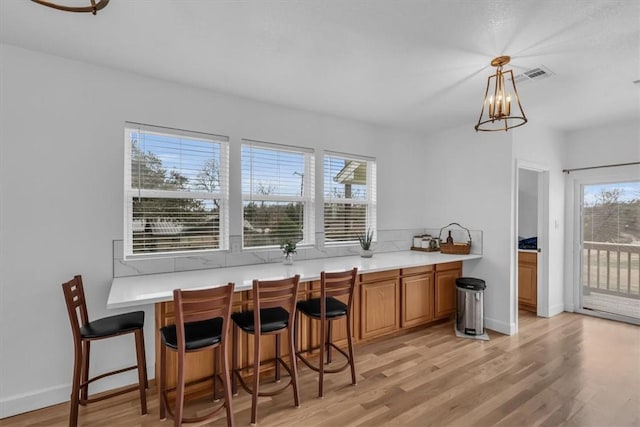 interior space with a chandelier, light wood-type flooring, and a healthy amount of sunlight