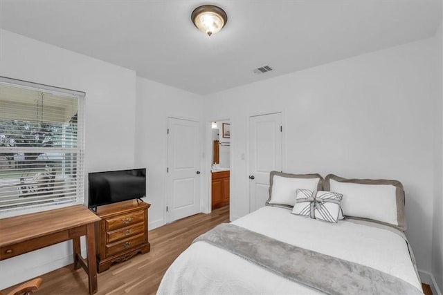 bedroom featuring light hardwood / wood-style floors and ensuite bathroom