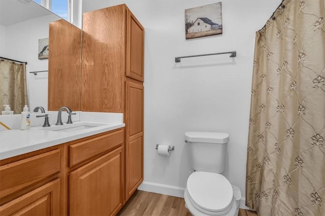 bathroom featuring vanity, toilet, wood-type flooring, and walk in shower