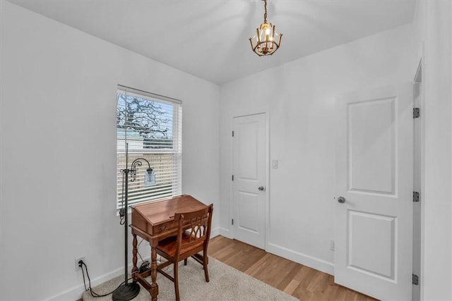 home office with a notable chandelier and light wood-type flooring