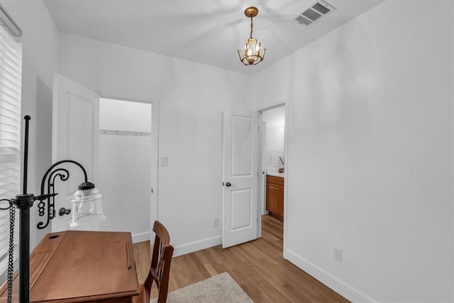 office area with light hardwood / wood-style flooring and a chandelier