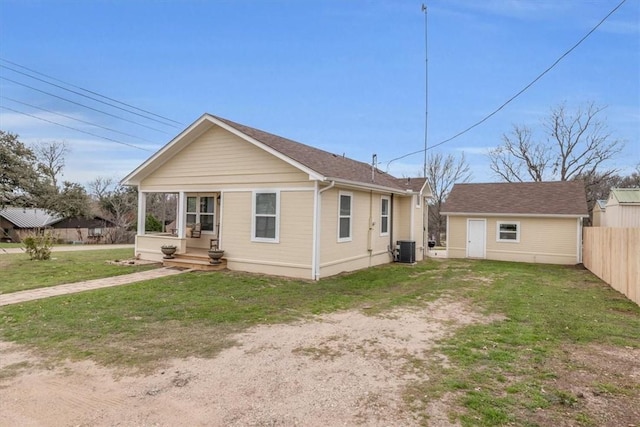 rear view of property with an outbuilding, cooling unit, and a lawn