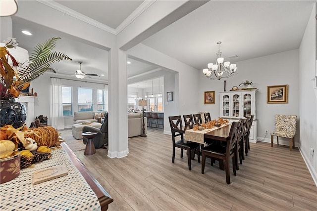 dining area with light hardwood / wood-style floors, ceiling fan with notable chandelier, and ornamental molding