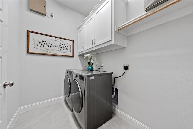 laundry area featuring light tile patterned flooring, cabinets, and independent washer and dryer