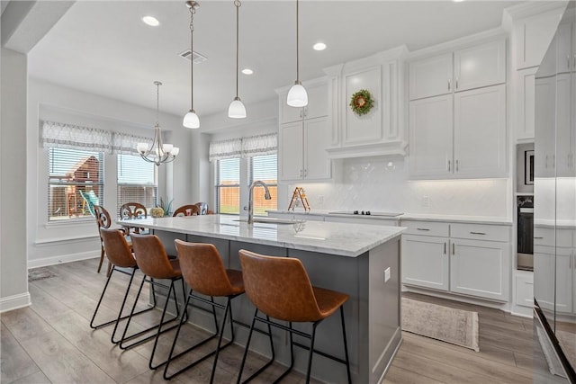 kitchen featuring plenty of natural light, light hardwood / wood-style floors, and an island with sink