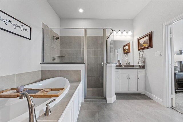 bathroom with tile patterned flooring, vanity, and independent shower and bath