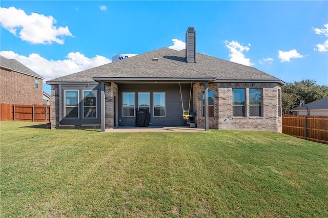 rear view of house featuring a yard and a patio