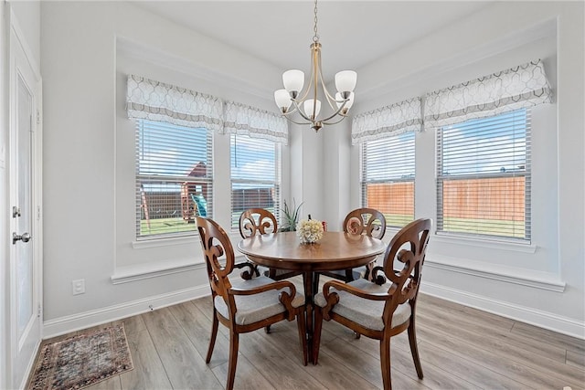 dining area featuring hardwood / wood-style flooring and a chandelier