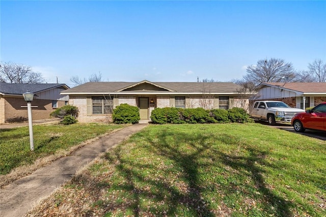 single story home with a front lawn and brick siding