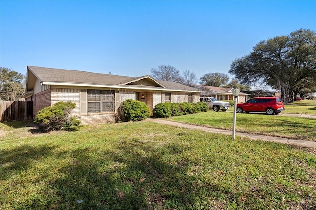 single story home with a front yard, brick siding, and fence