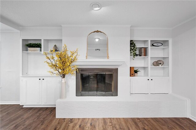 interior details with a tiled fireplace, wood-type flooring, and crown molding