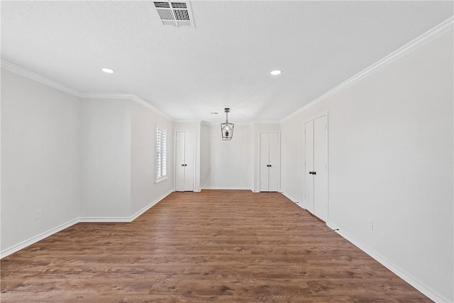 spare room featuring hardwood / wood-style floors and crown molding