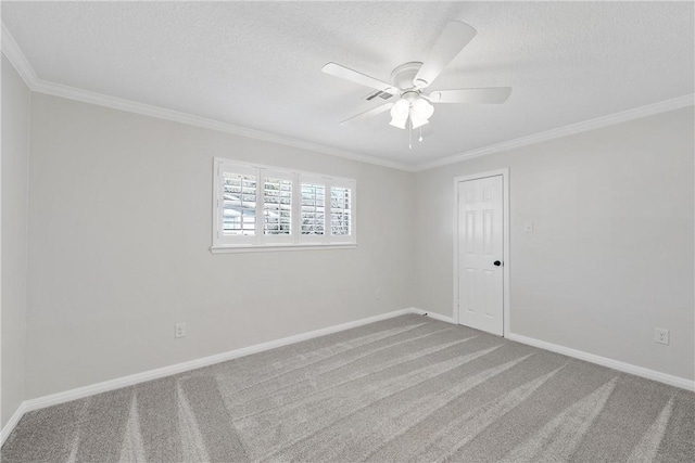 carpeted empty room with ceiling fan, ornamental molding, and a textured ceiling