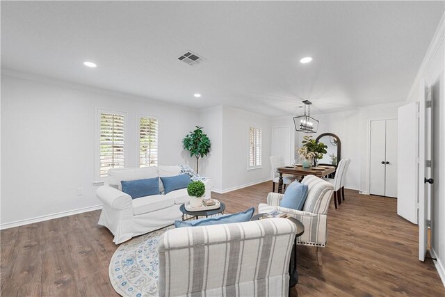 unfurnished dining area featuring ornamental molding, dark wood-type flooring, and a notable chandelier