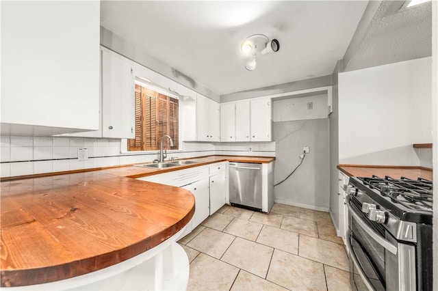 kitchen with white cabinetry, sink, decorative backsplash, light tile patterned flooring, and appliances with stainless steel finishes