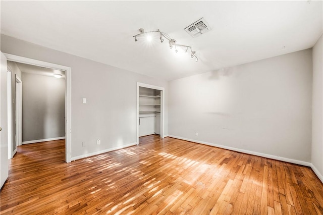 unfurnished bedroom featuring hardwood / wood-style floors and a closet