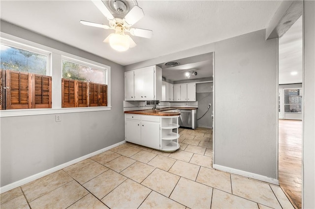 kitchen featuring ceiling fan, dishwasher, white cabinets, butcher block countertops, and light tile patterned flooring