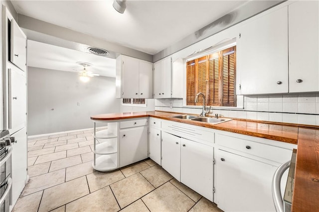 kitchen featuring white cabinets, light tile patterned flooring, ceiling fan, and sink