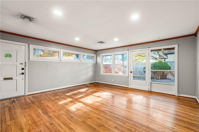 interior space with crown molding and light hardwood / wood-style flooring